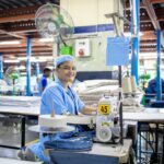 Worker sewing fabric in a textile factory
